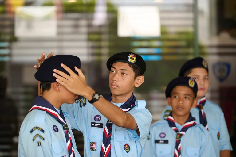 APS student fixing his schoolmate's hat