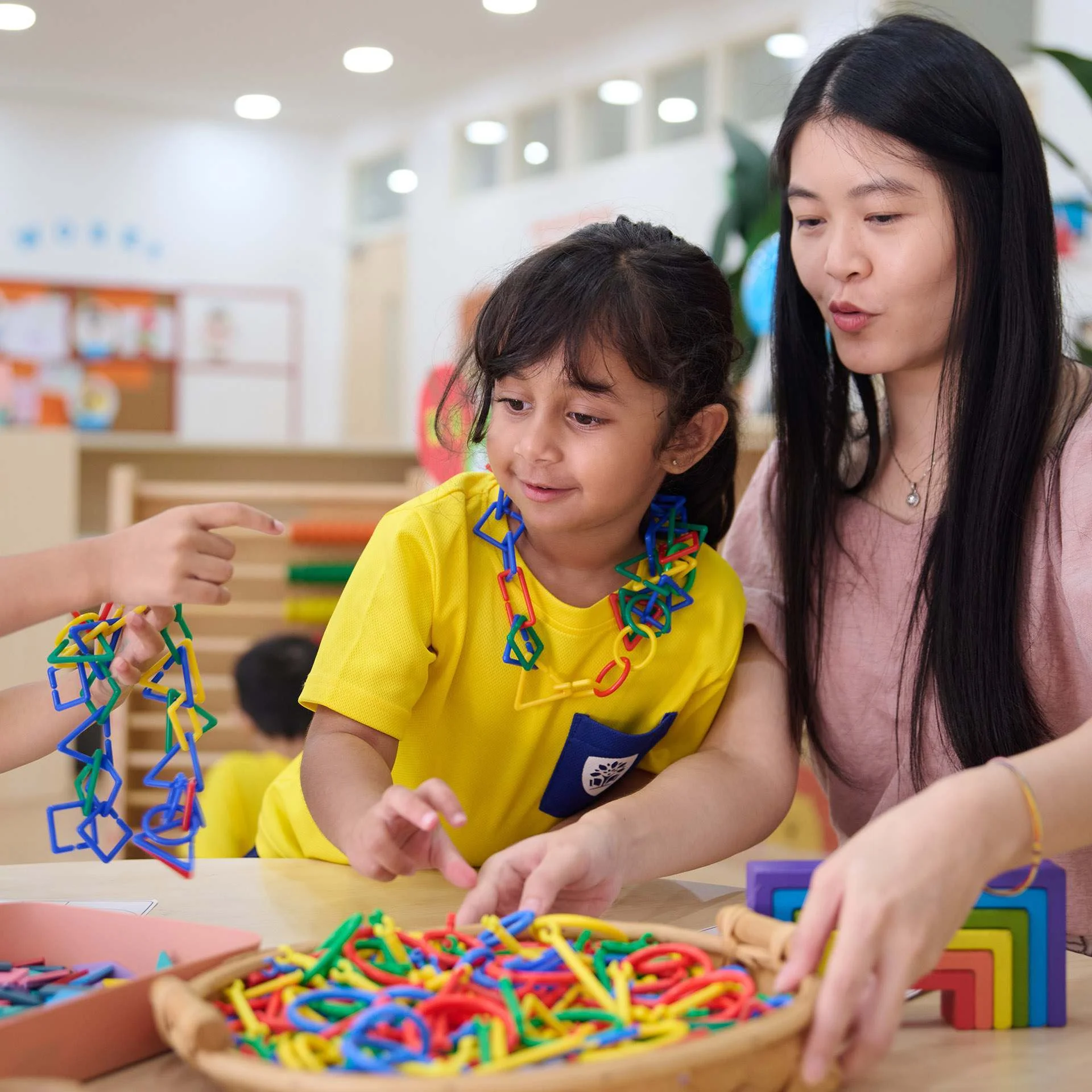 Kid playing while being assisted by her teacher
