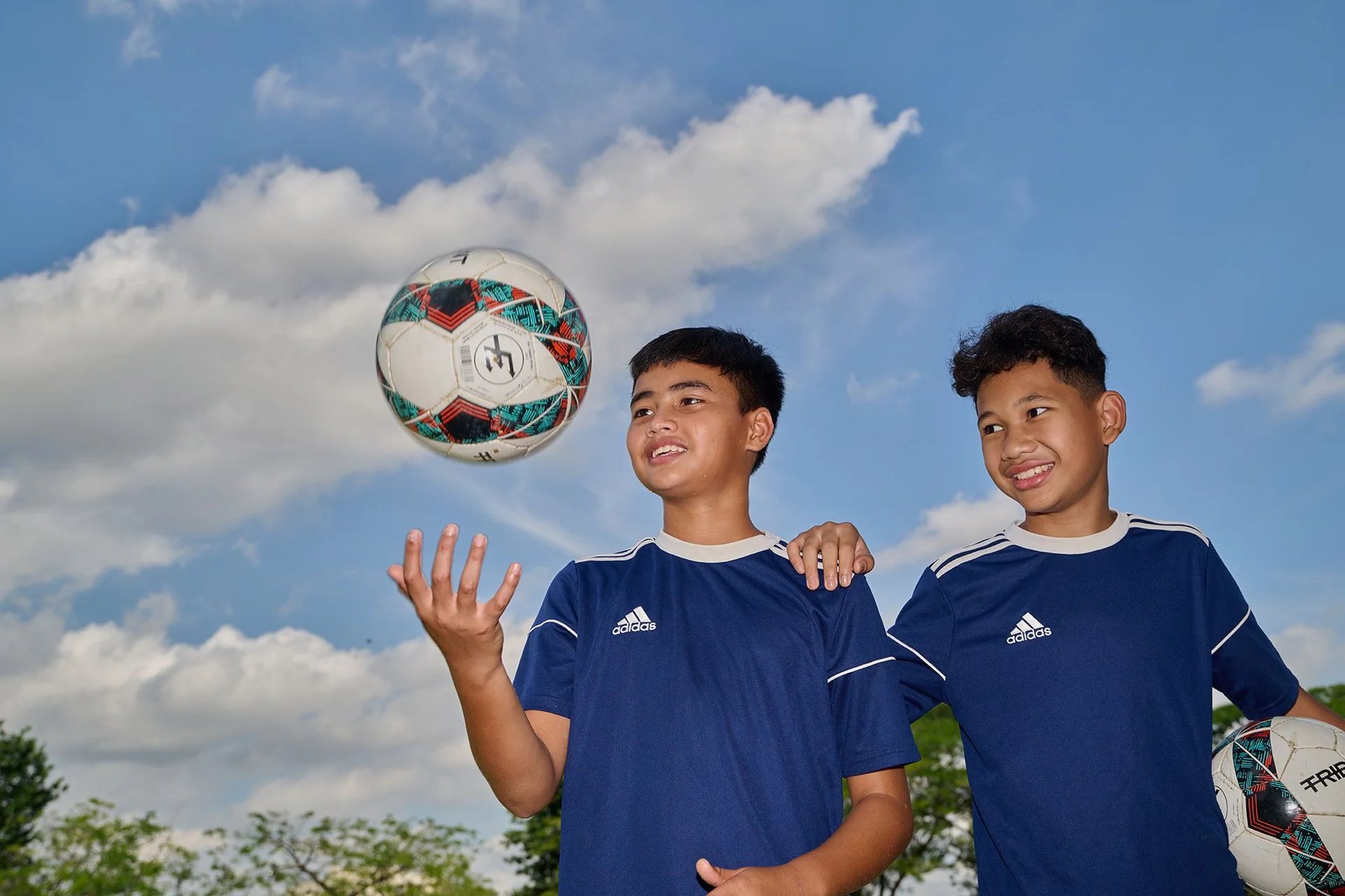 Boys smiling and playing with footballs