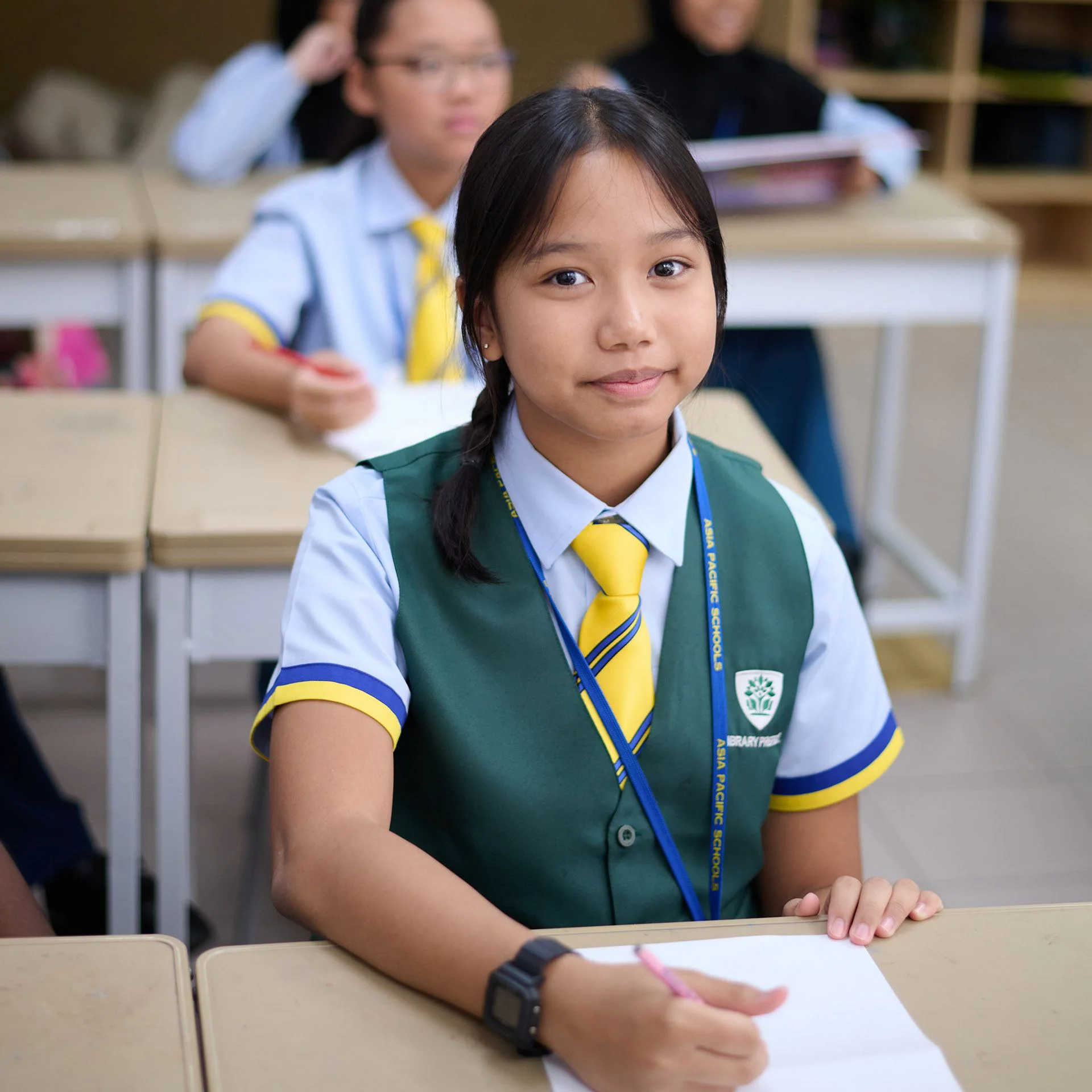 Student smiling while taking notes