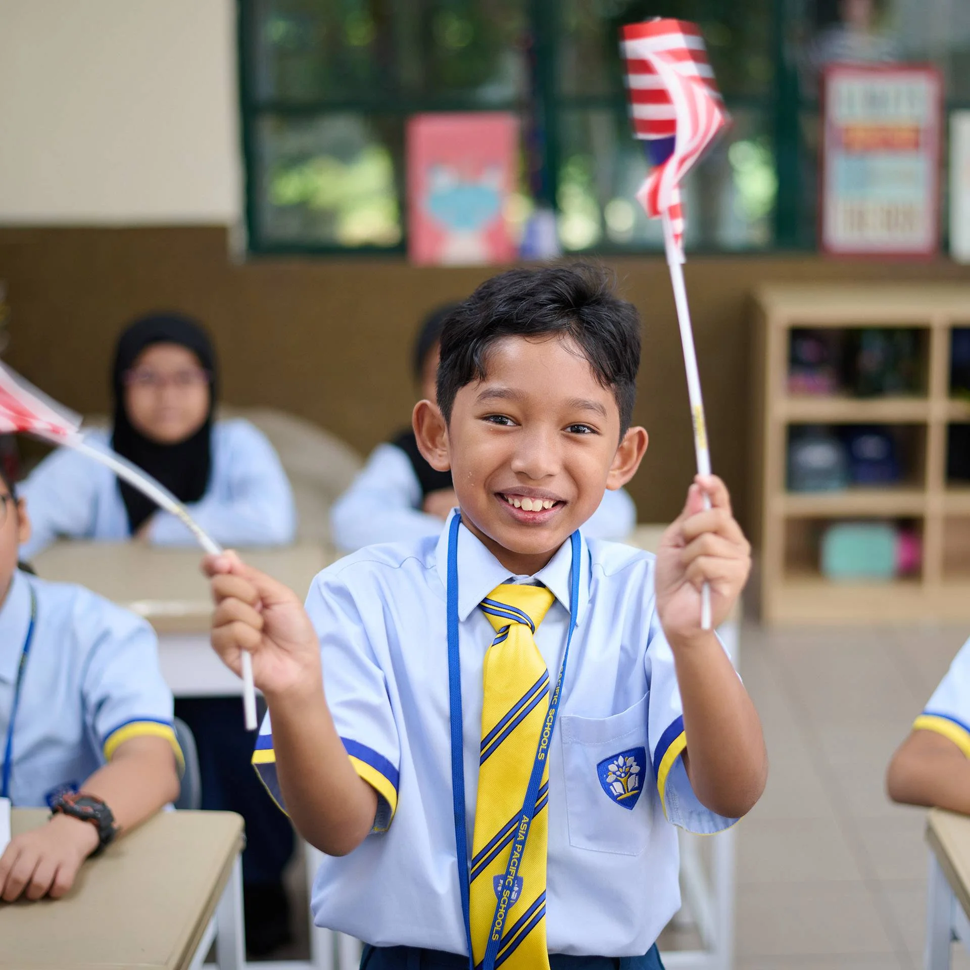 Kid smiling and waving Malaysian flags