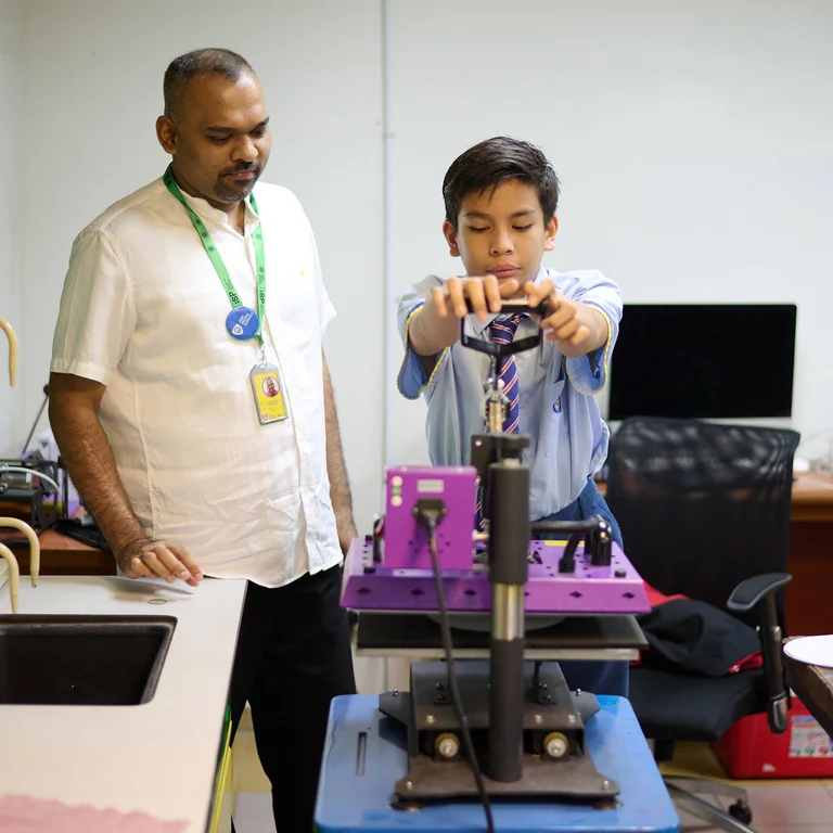 Student doing lab activities while being supervised by a teacher