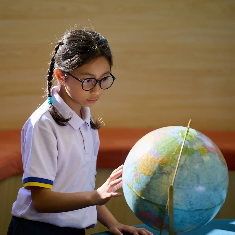 Kid looking at a globe