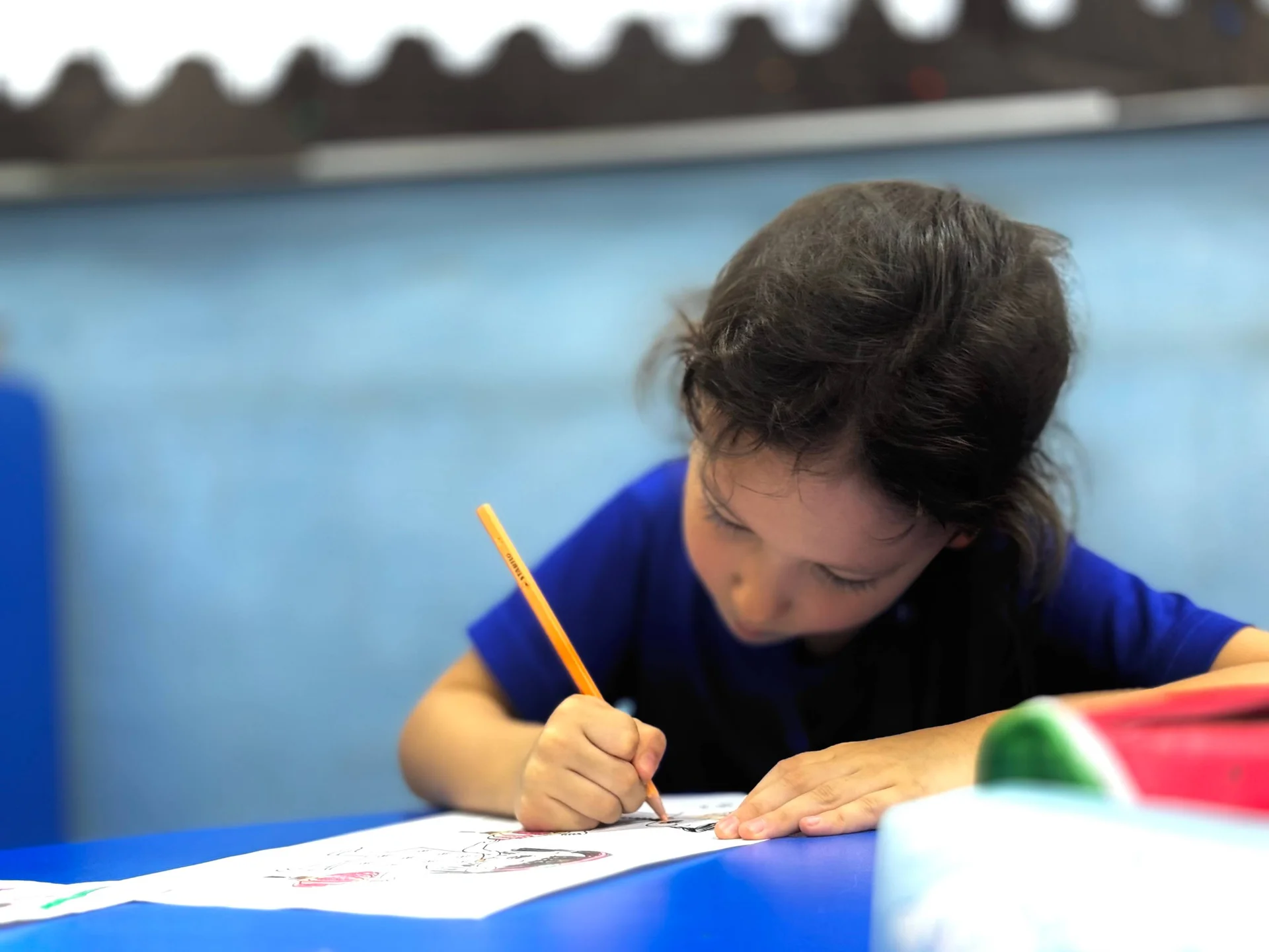 Child looking down while drawing