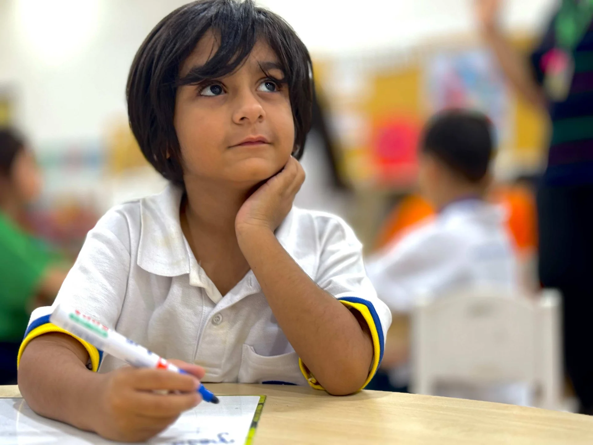 Kid with a marker in her hand looking up