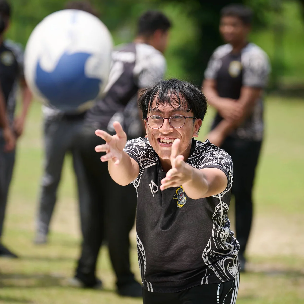 Teenager smiling and catching a rugby ball