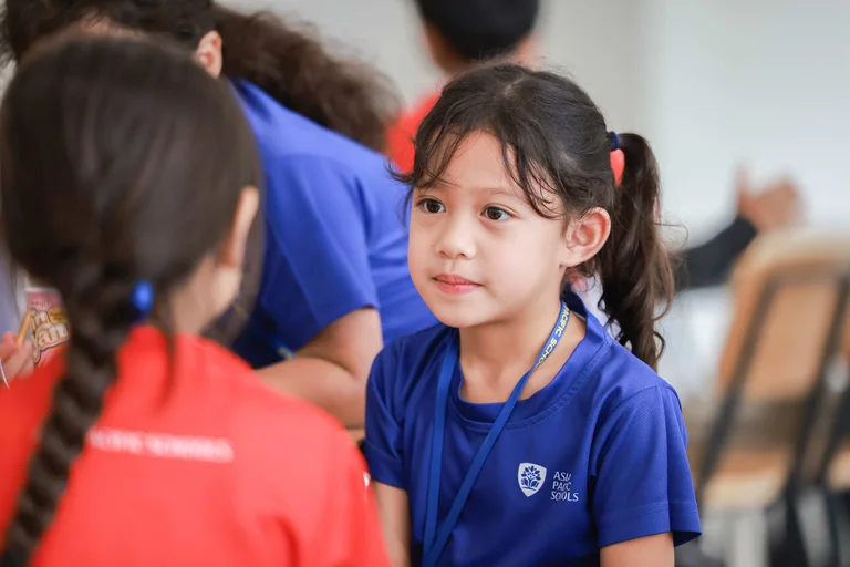 APS student looking at one of her classmates