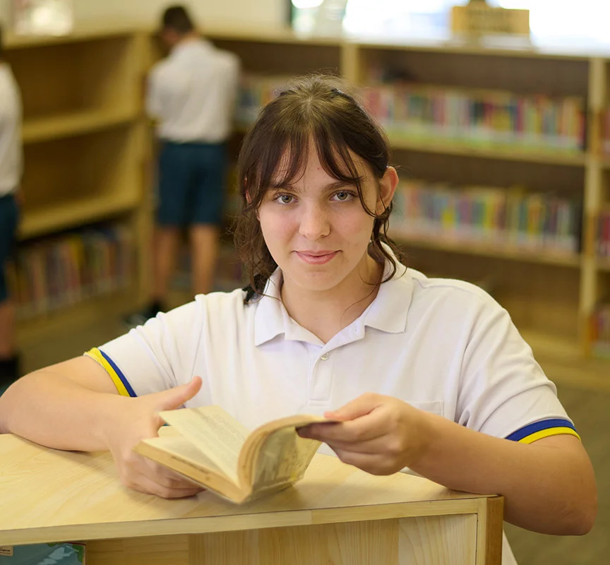 Secondary school student holding a book in her hands